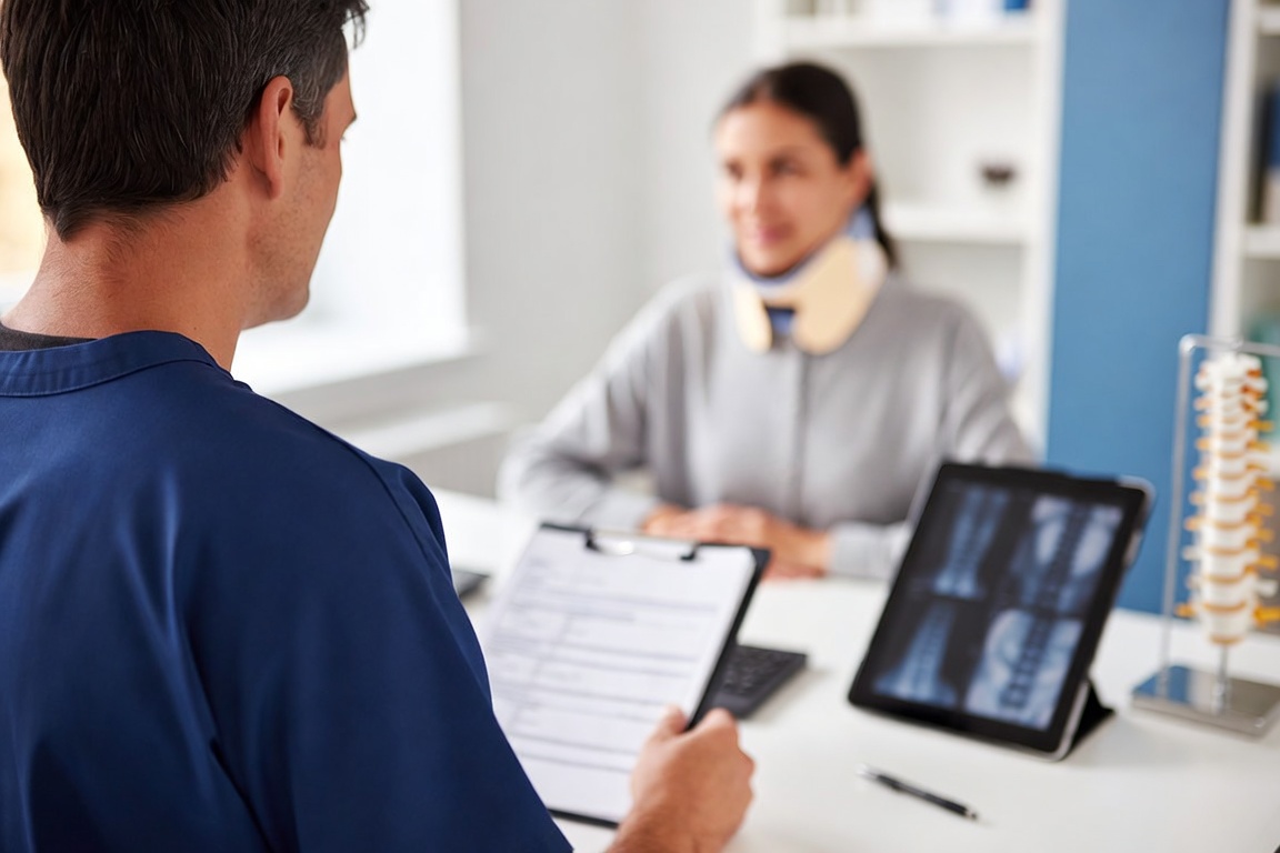 Personal injury chiropractor reviewing injury records with a patient in Garland, TX